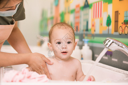 阿姨给婴幼儿洗澡特写图片