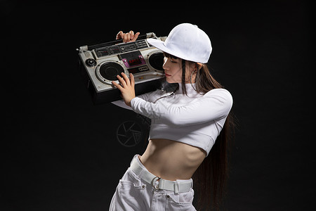 年轻街舞女生肩膀扛着录音机背景图片