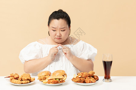 餐桌垃圾肥胖女生纠结吃垃圾油炸食品背景