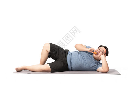 健身零食肥胖男生躺在瑜伽垫上吃零食背景