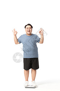 肥胖男士站在体重秤上开心表情高清图片