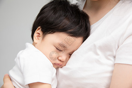 年轻妈妈抱着熟睡的宝宝图片