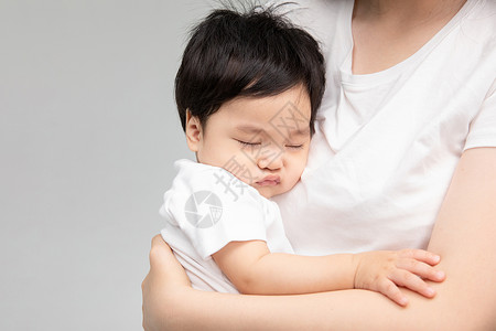 年轻妈妈抱着熟睡的宝宝高清图片