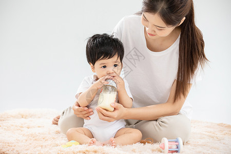 喝奶的人年轻妈妈用奶瓶辅助宝宝喝奶背景