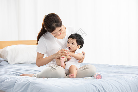 年轻妈妈用奶瓶辅助宝宝喝奶背景