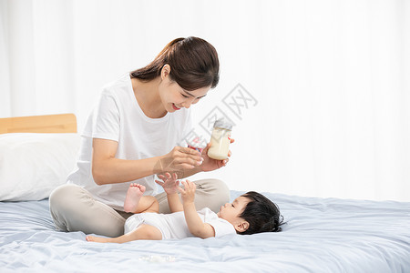 女人喝奶年轻妈妈用奶瓶哺育宝宝喝奶背景