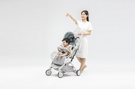 婴儿手推车年轻妈妈用婴儿车带娃背景