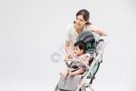 婴儿手推车年轻妈妈用婴儿车带娃背景