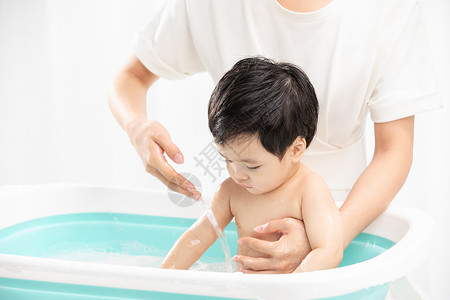 母子洗澡年轻妈妈给孩子洗澡背景