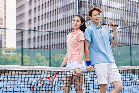 生活素材网网球场上打网球的年轻情侣背景