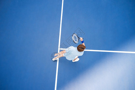 挥拍打网球的男性运动员高清图片
