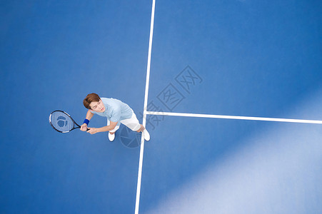 挥拍打网球的男性运动员高清图片
