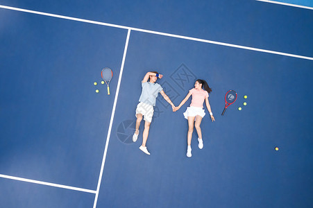 躺在网球场地上休息的青年情侣图片