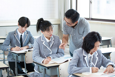 老师给学生辅导课堂作业背景图片