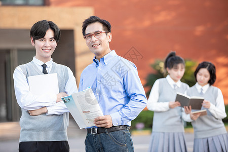 校园里学生和老师讨论课本知识图片