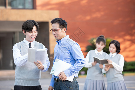 上学校校园里学生和老师讨论课本知识背景