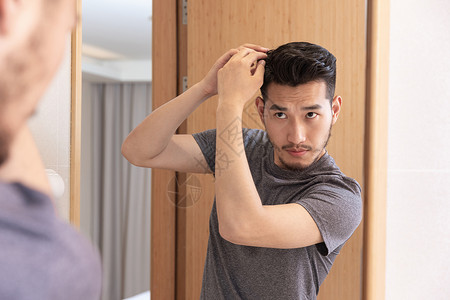 成熟男性照镜子整理发型高清图片