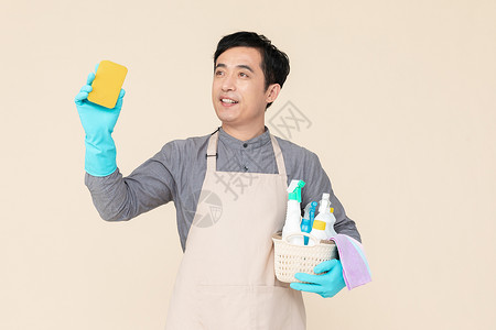 海棉拿海绵刷与清洁用品的保洁男性背景