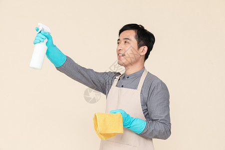 手持喷壶与抹布做清洁的家政服务男性背景