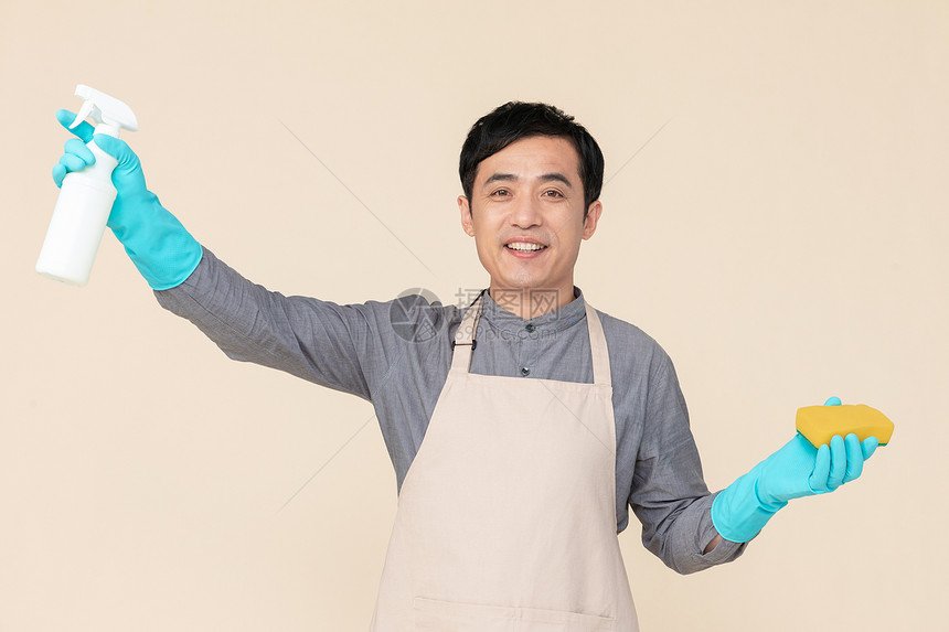 手持喷壶与海绵做清洁的家政服务男性图片