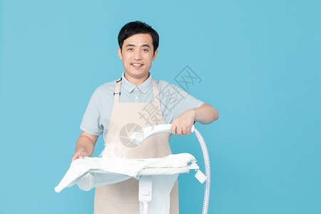 使用挂烫机熨烫衣服的家政服务男性背景图片