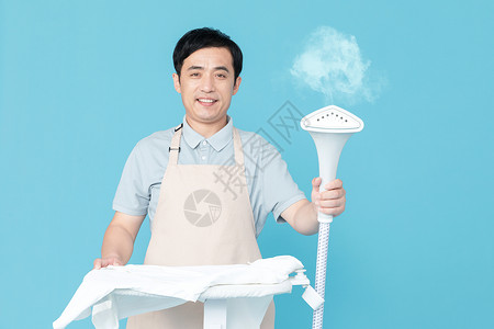 蒸汽挂烫机使用挂烫机熨烫衣服的家政服务男性背景