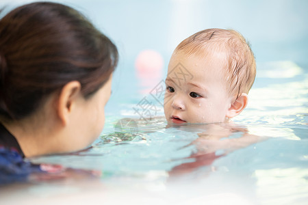 幼儿游泳馆母亲带着婴儿水池游泳背景