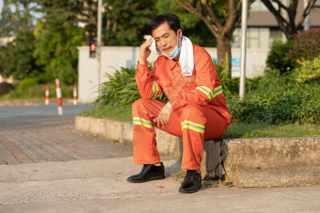 坐在马路旁休息的环卫工人图片