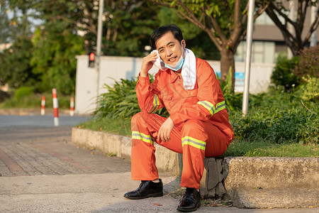 坐在马路旁休息的环卫工人图片
