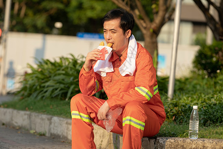 坐在马路旁吃油条的环卫工人图片