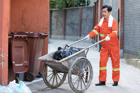 服装分类素材环卫工人推着装垃圾的推车背景