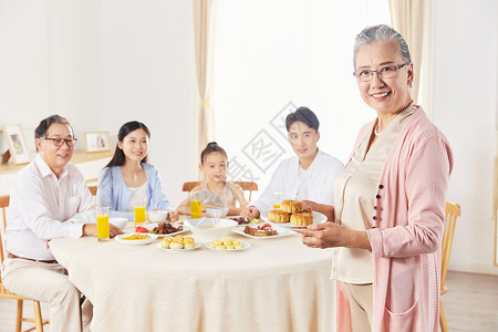 奶奶端着月饼给一家人吃高清图片