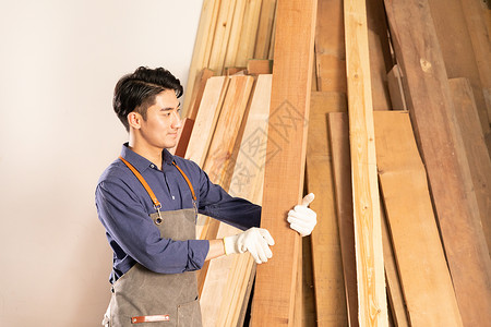 男性木工挑选木材物料图片