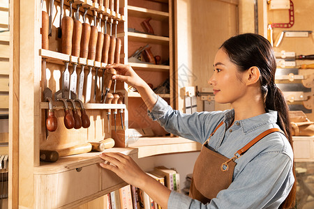 木匠美女工人检查手工工具图片