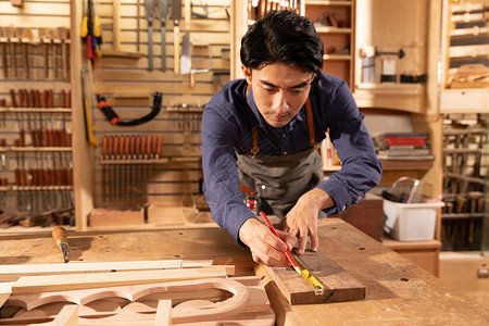 木匠男性工人测量木料背景图片