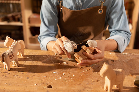 女性匠人制作木块雕刻特写图片