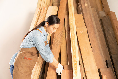 女性工匠挑选木材物料背景图片