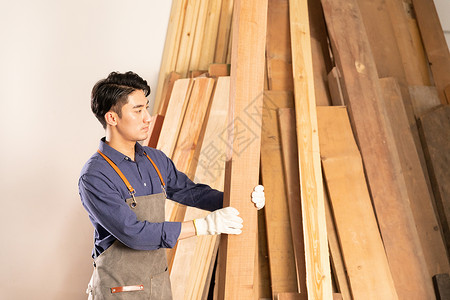 男性木工挑选木材物料背景图片