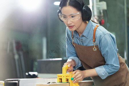 木匠美女工人检查手工工具背景