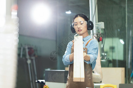 木匠美女工人看木材物料背景图片