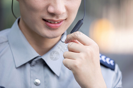 保安使用蓝牙耳机汇报工作特写图片