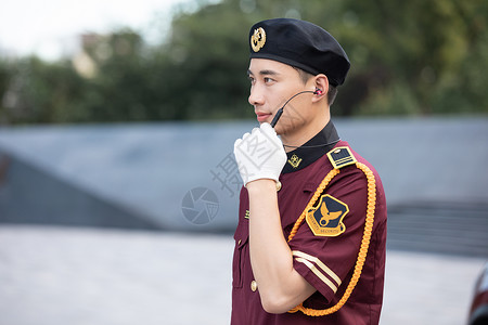 保安户外巡逻手扶耳麦讲话背景图片