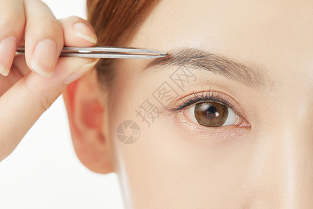 女性使用镊子修整眉形高清图片