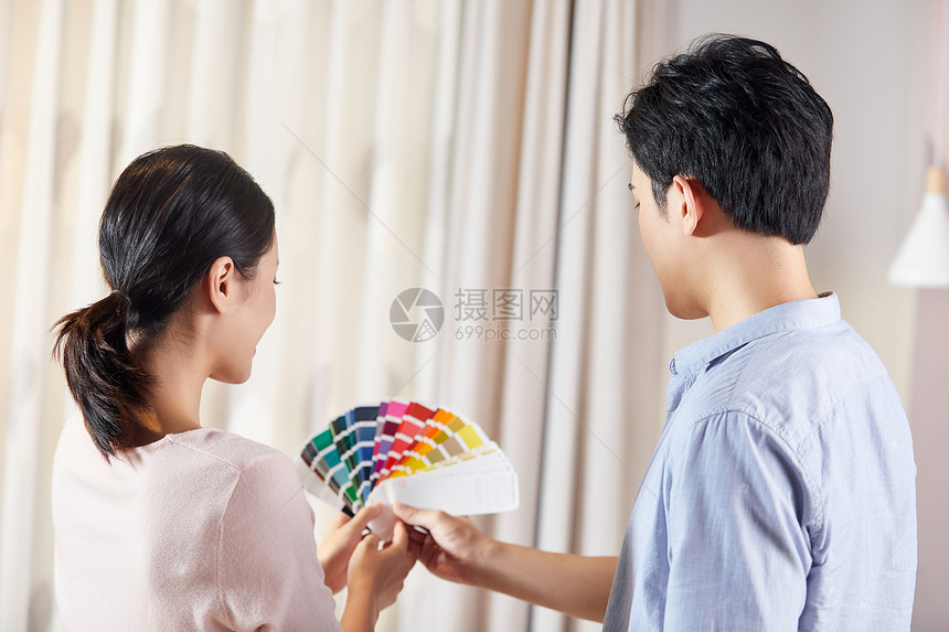 年轻夫妻家具店选购窗帘背影图片