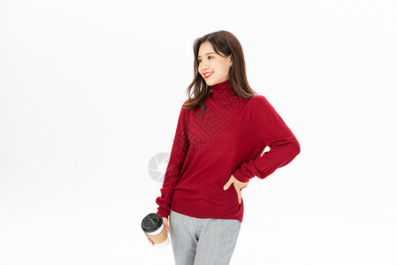 穿红色毛衣的女性手捧咖啡杯高清图片