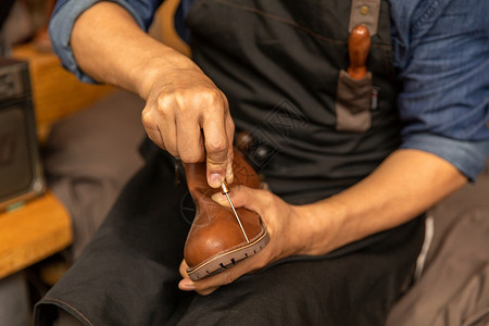 中年男性皮匠修理皮鞋中年男性鞋匠工匠修理皮鞋背景