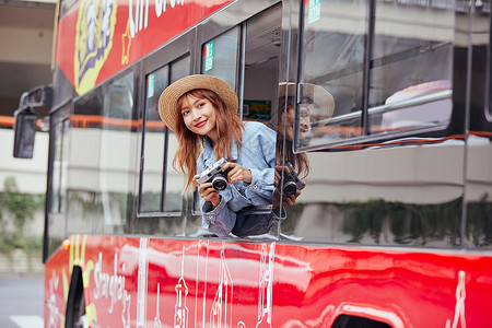 坐巴士坐观光大巴旅游拍照的年轻女孩背景