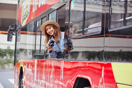 十一欢乐购坐观光大巴旅游拍照的年轻女孩背景