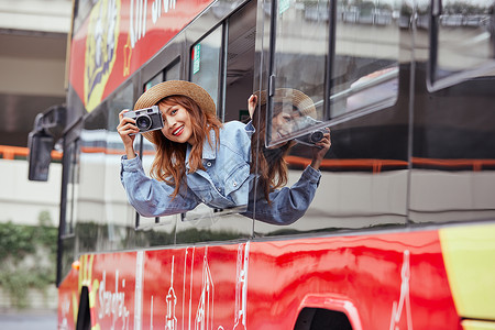 十一欢乐购坐观光大巴旅游拍照的年轻女孩背景