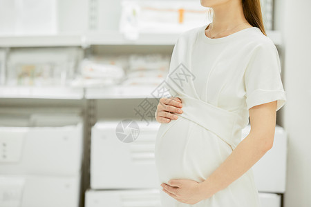 产妇用品孕妇手扶着肚子背景